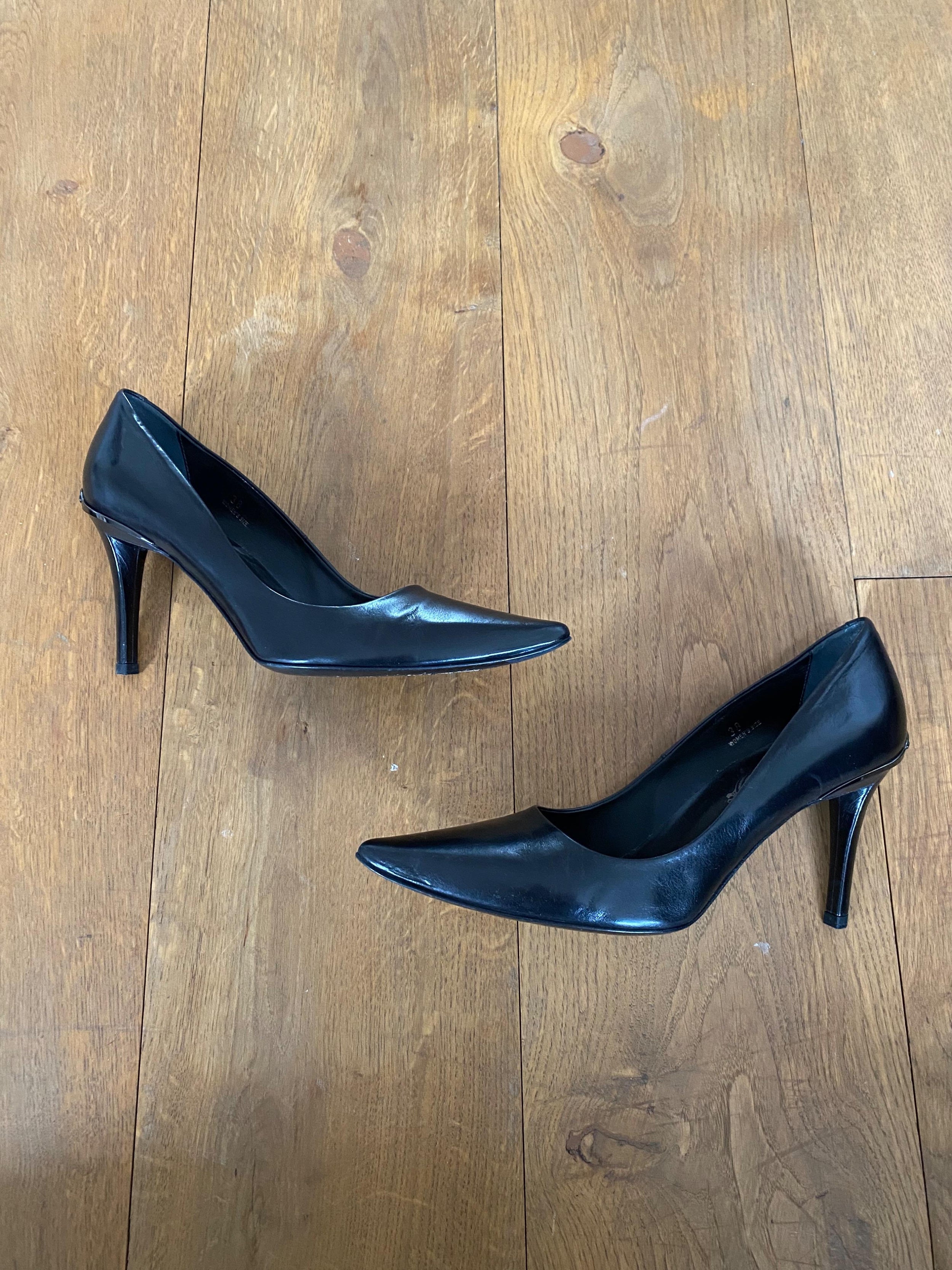 Black leather point toe heeled pumps