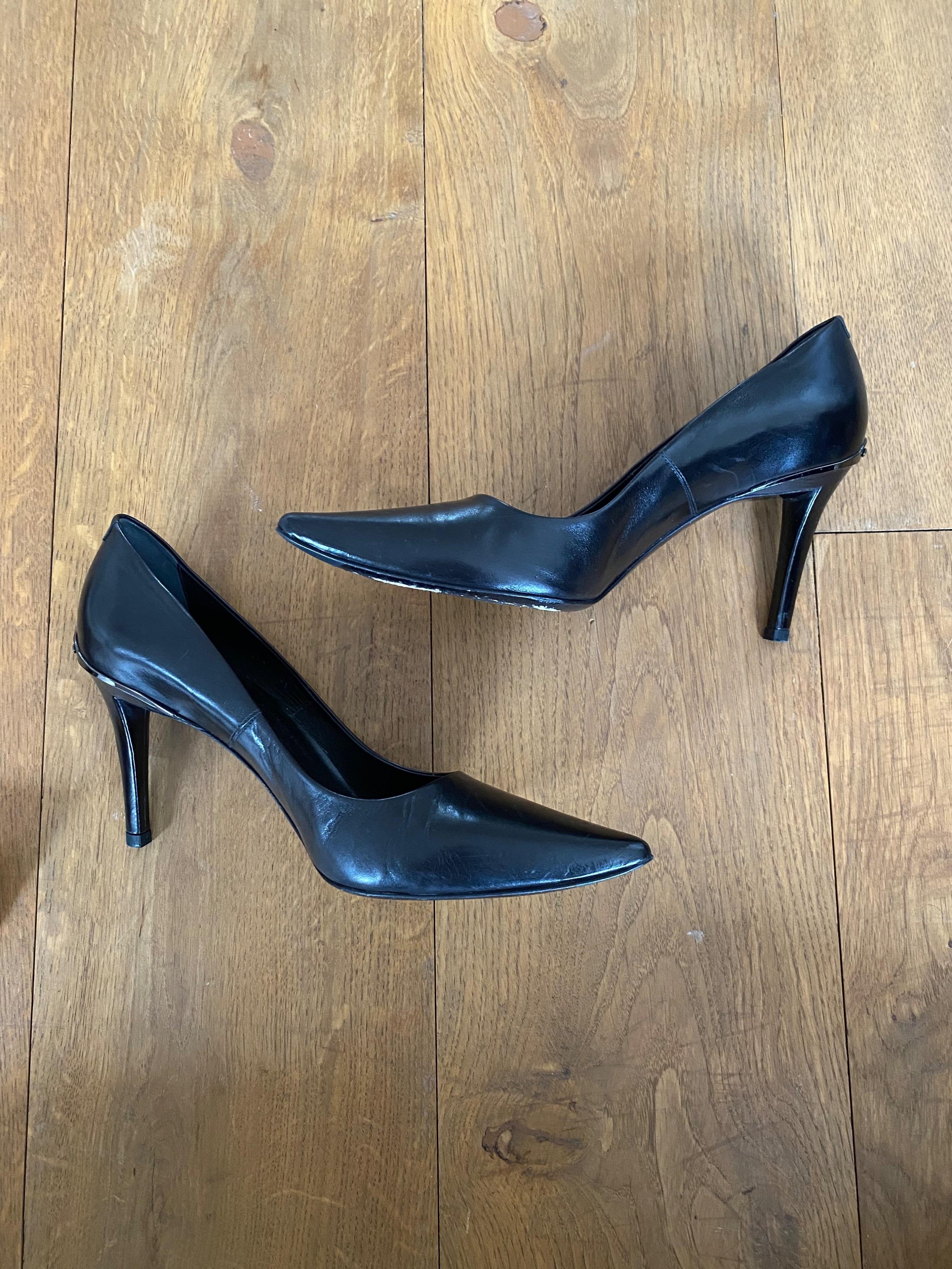 Black leather point toe heeled pumps
