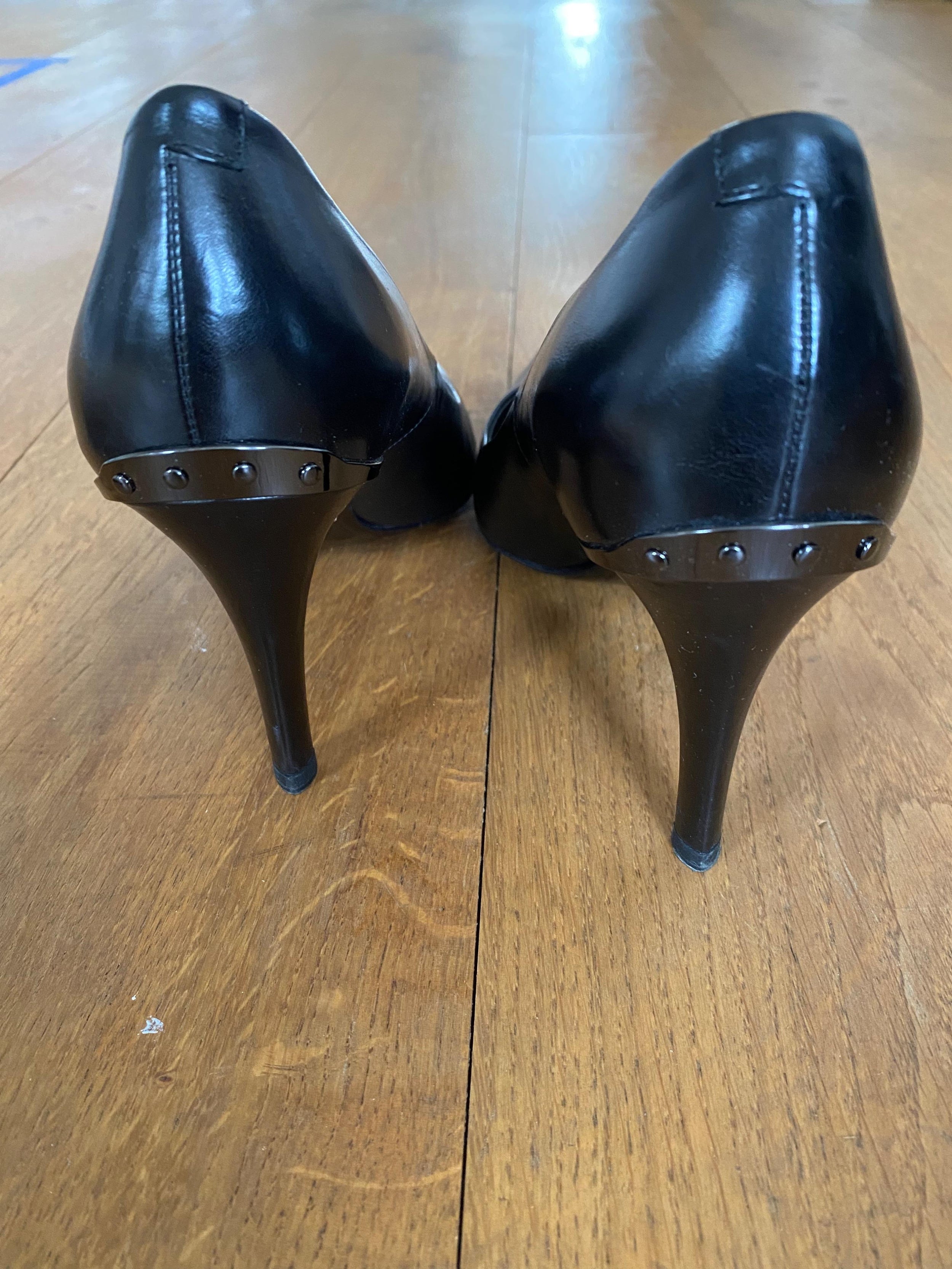 Black leather point toe heeled pumps